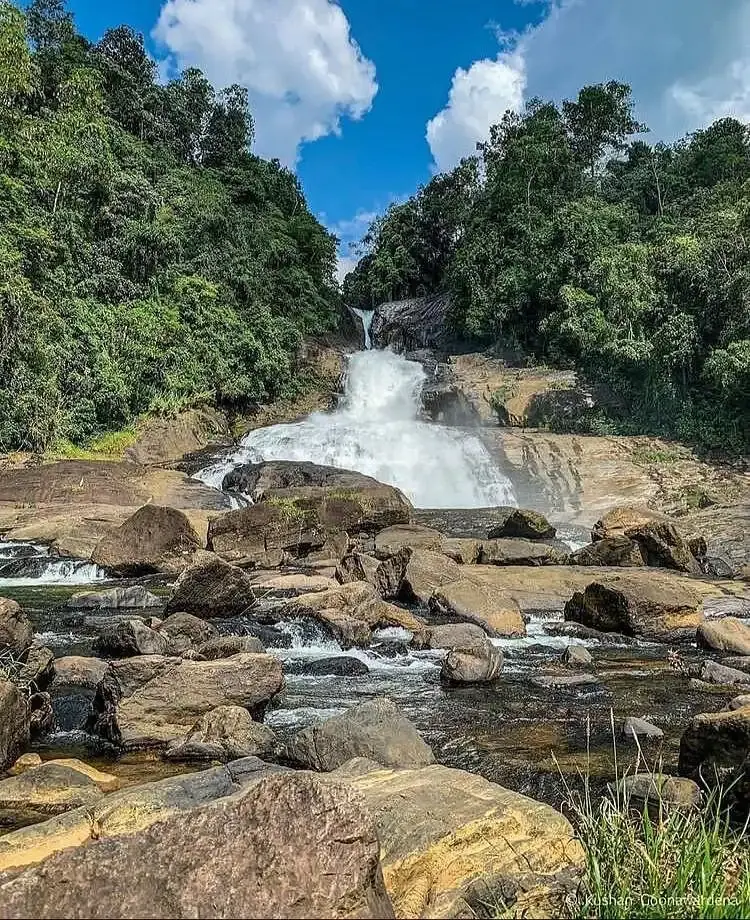A hand holding several large, uncut gemstones.